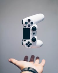 Person's hand catching a game console controller